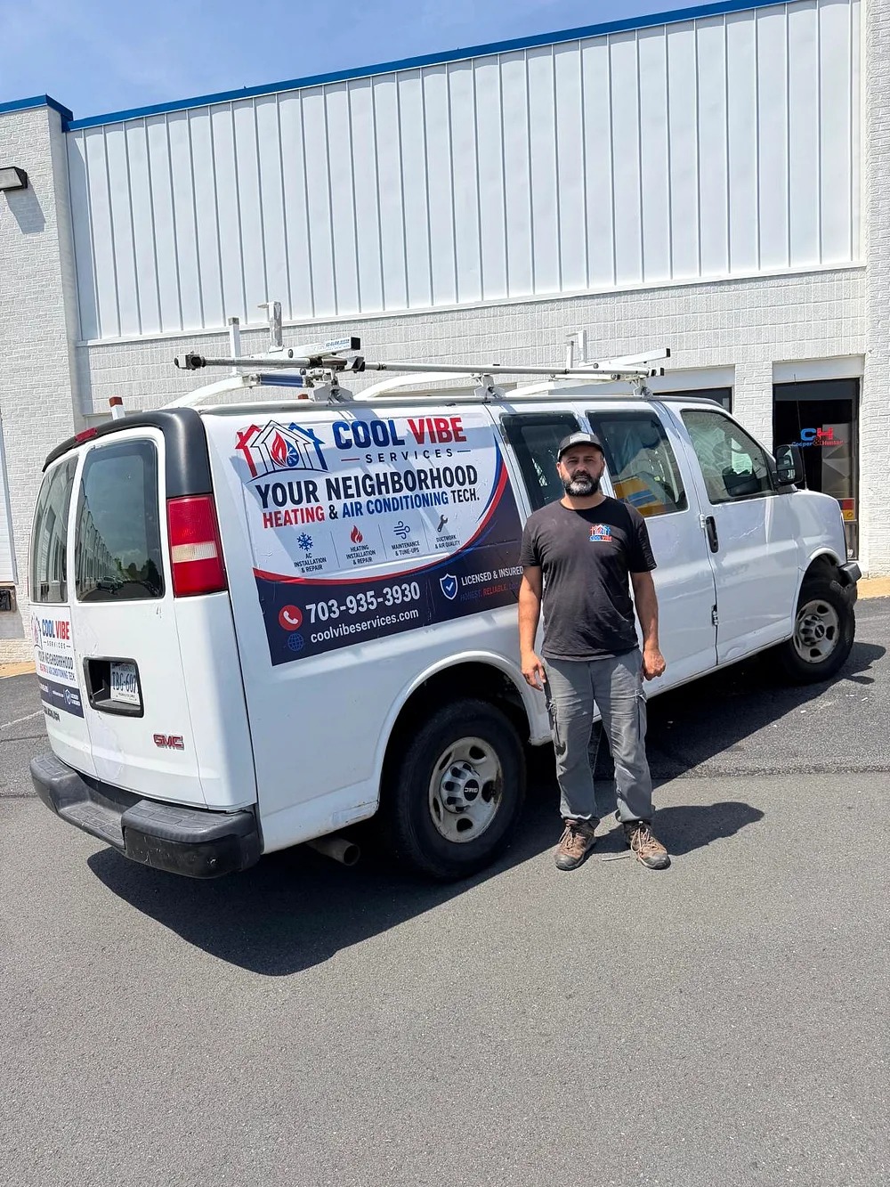 Ahmad Afzaal, owner of Coolvibe Services, standing beside the company's branded HVAC van